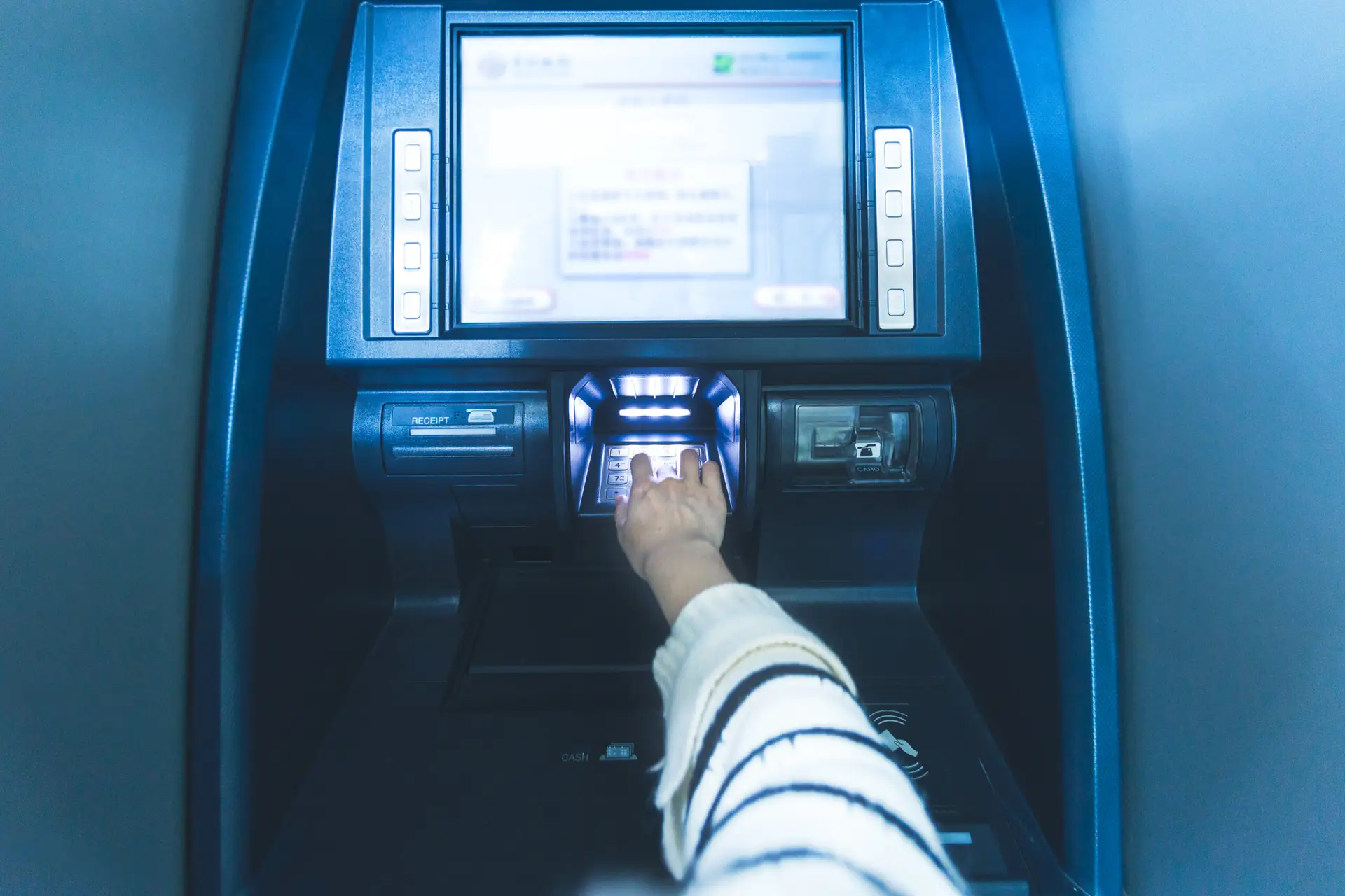 Woman using cash machine-ATM, close up view